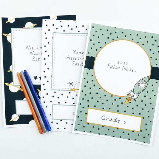 Space theme binder book covers displayed on white desk