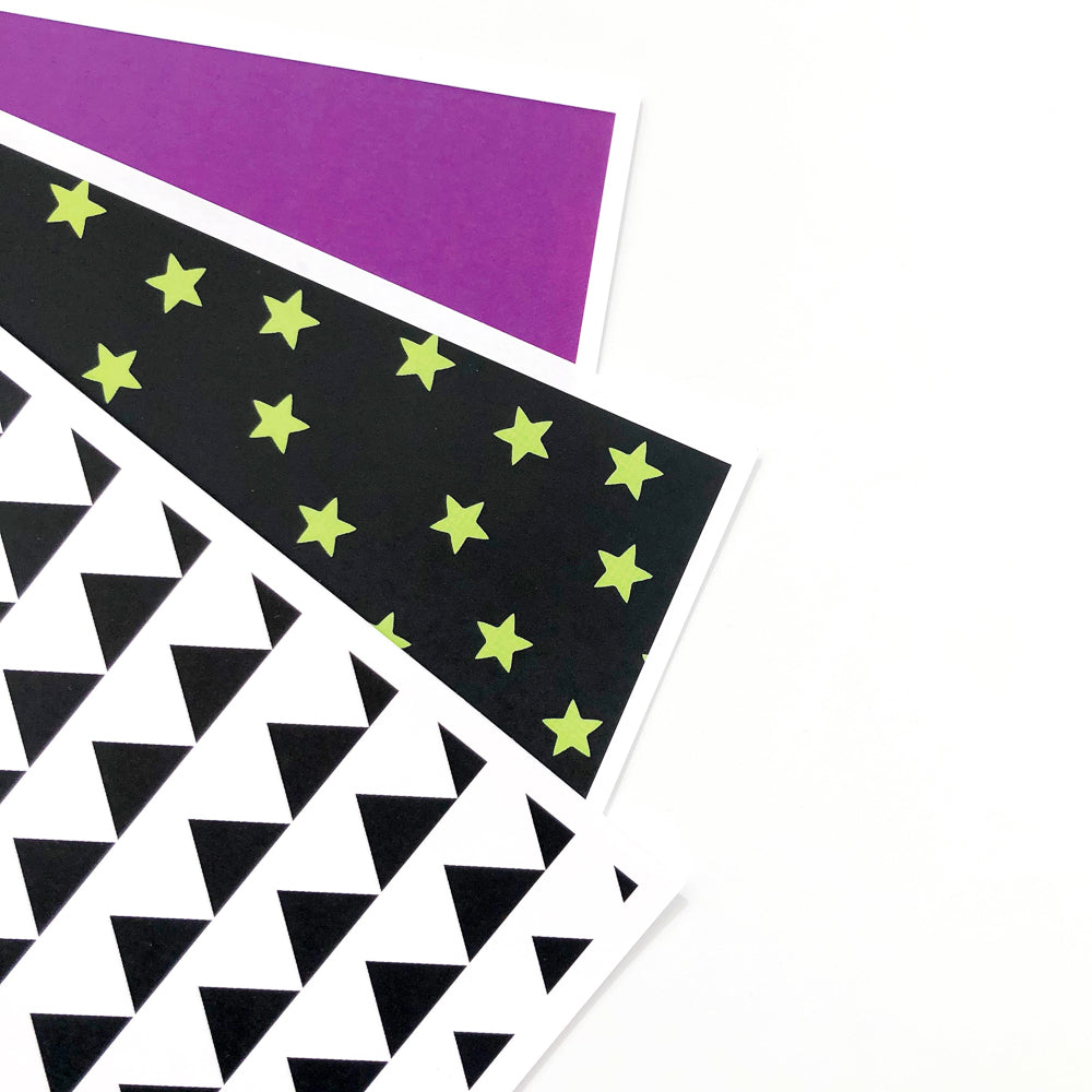 Three pieces of paper displayed on white background with halloween colours and shapes.