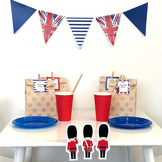 London themed party table set up featuring british themed printables and a white table. 