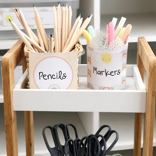Pencils, Markers and Scissors on a classroom trolley labelled with rainbow theme labels.