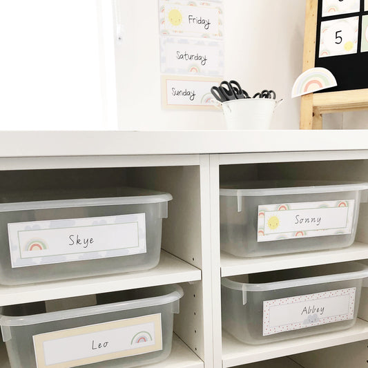 Pastel Rainbow themed name labels on tubs in cubby holes in classroom. 