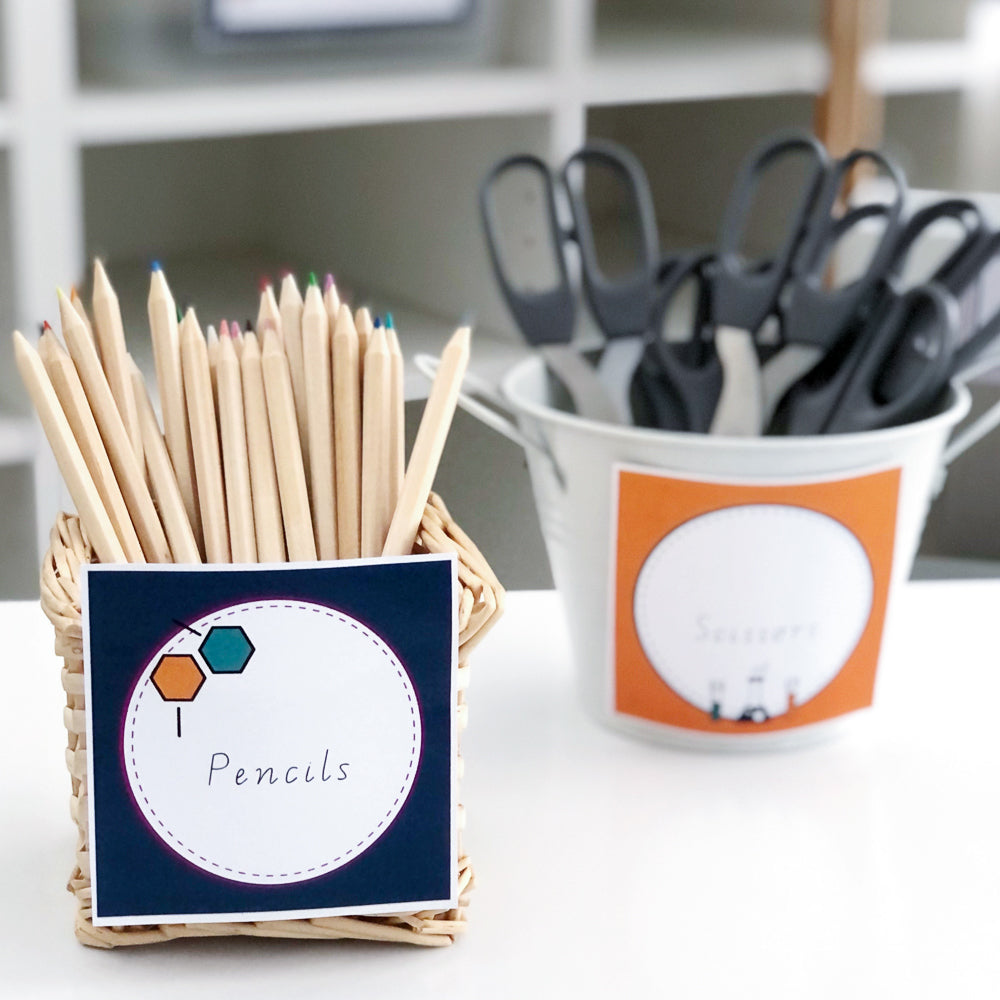 Two caddies with school supplies in them and science them labels attached to the front. 